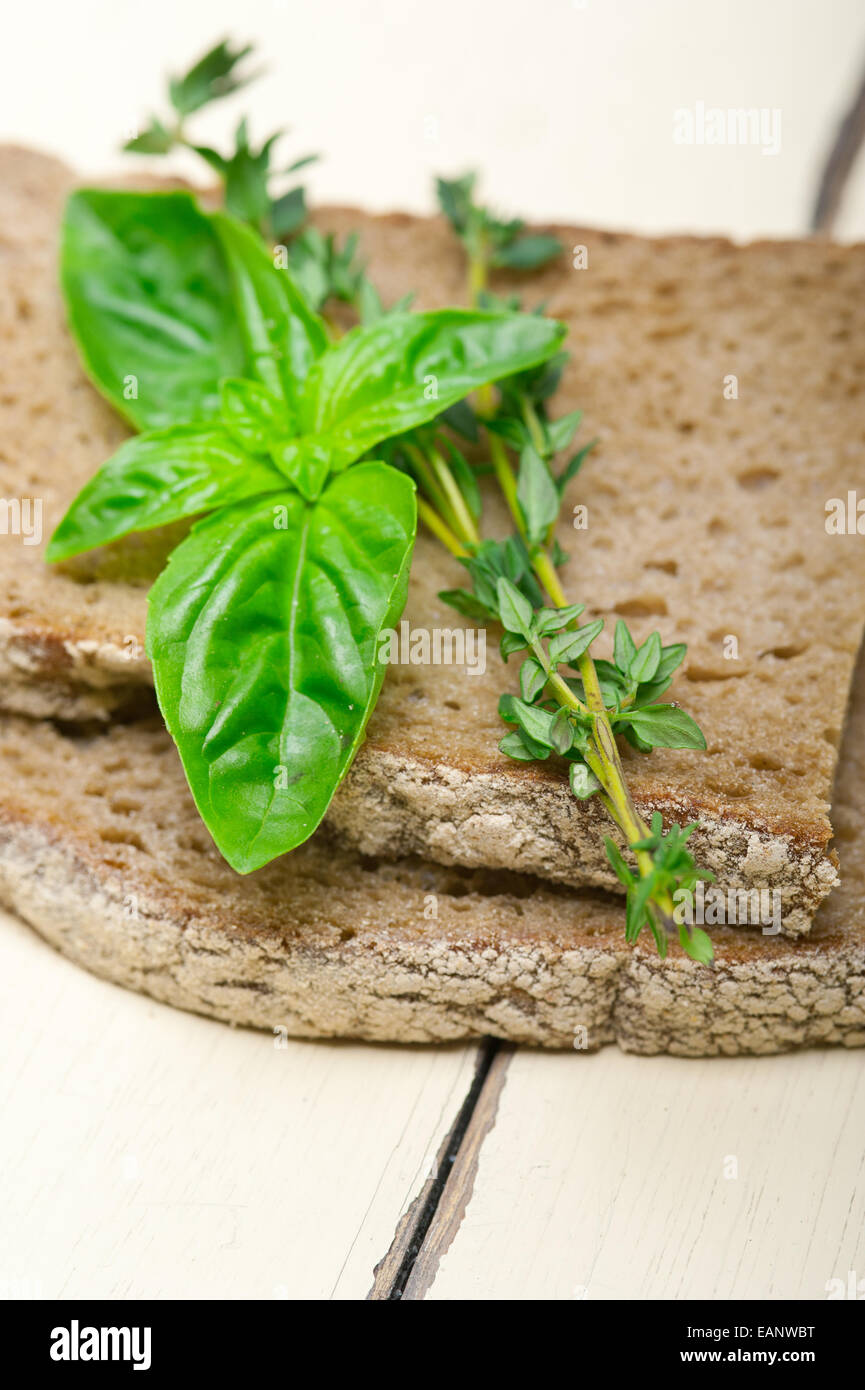 Pane rustico italiano il basilico e il timo semplice spuntino sul bianco tavola di legno Foto Stock