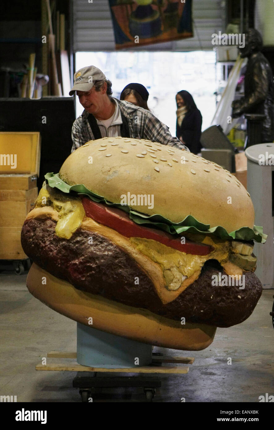 Burnaby, Canada. Xviii Nov, 2014. Uno staff di magazzino trasporta un gigante hamburger puntelli all'asta preview evento in Burnaby, Canada, nov. 18, 2014. Vancouver la più grande prop casa sta per asta oltre 800 movie props. © Liang Sen/Xinhua/Alamy Live News Foto Stock