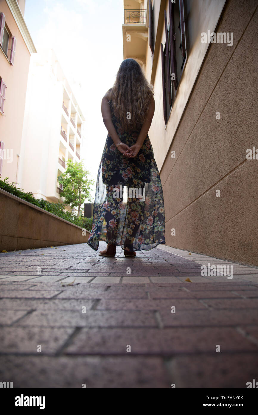 Giovane donna in piedi in vicolo Foto Stock