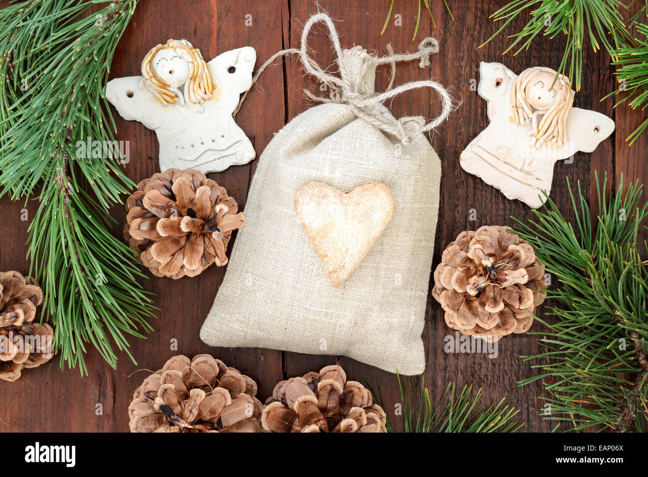 Regalo di natale in lino, decorata con cuore di panpepato, angeli e ramoscelli di pino Foto Stock