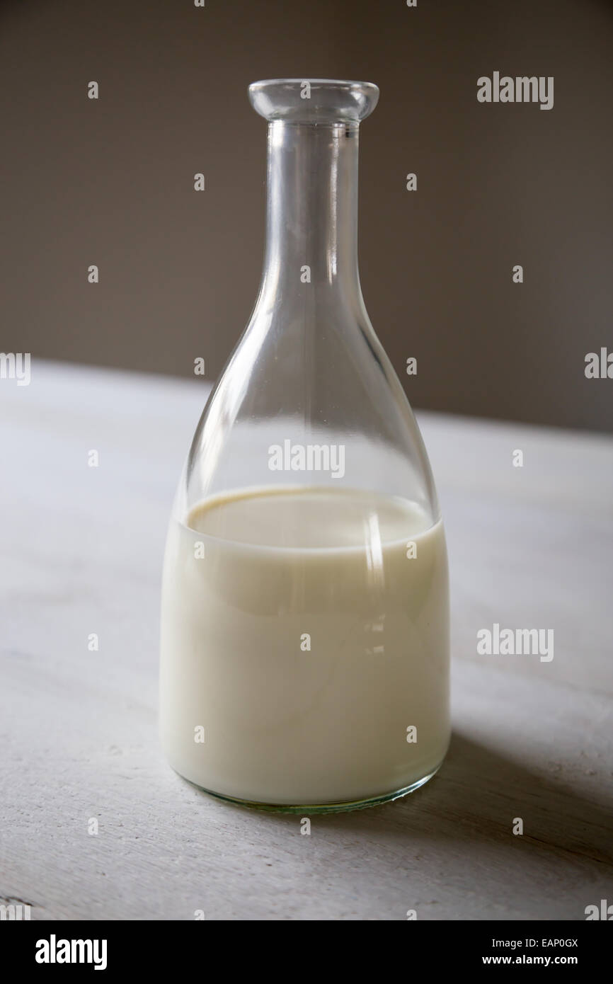 Latte in un recipiente su un tavolo di legno Foto Stock