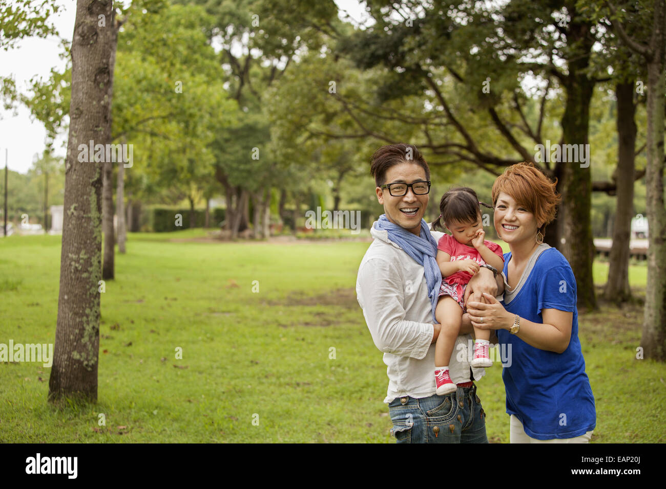 La famiglia in un parco. Due genitori e un bambino. Foto Stock