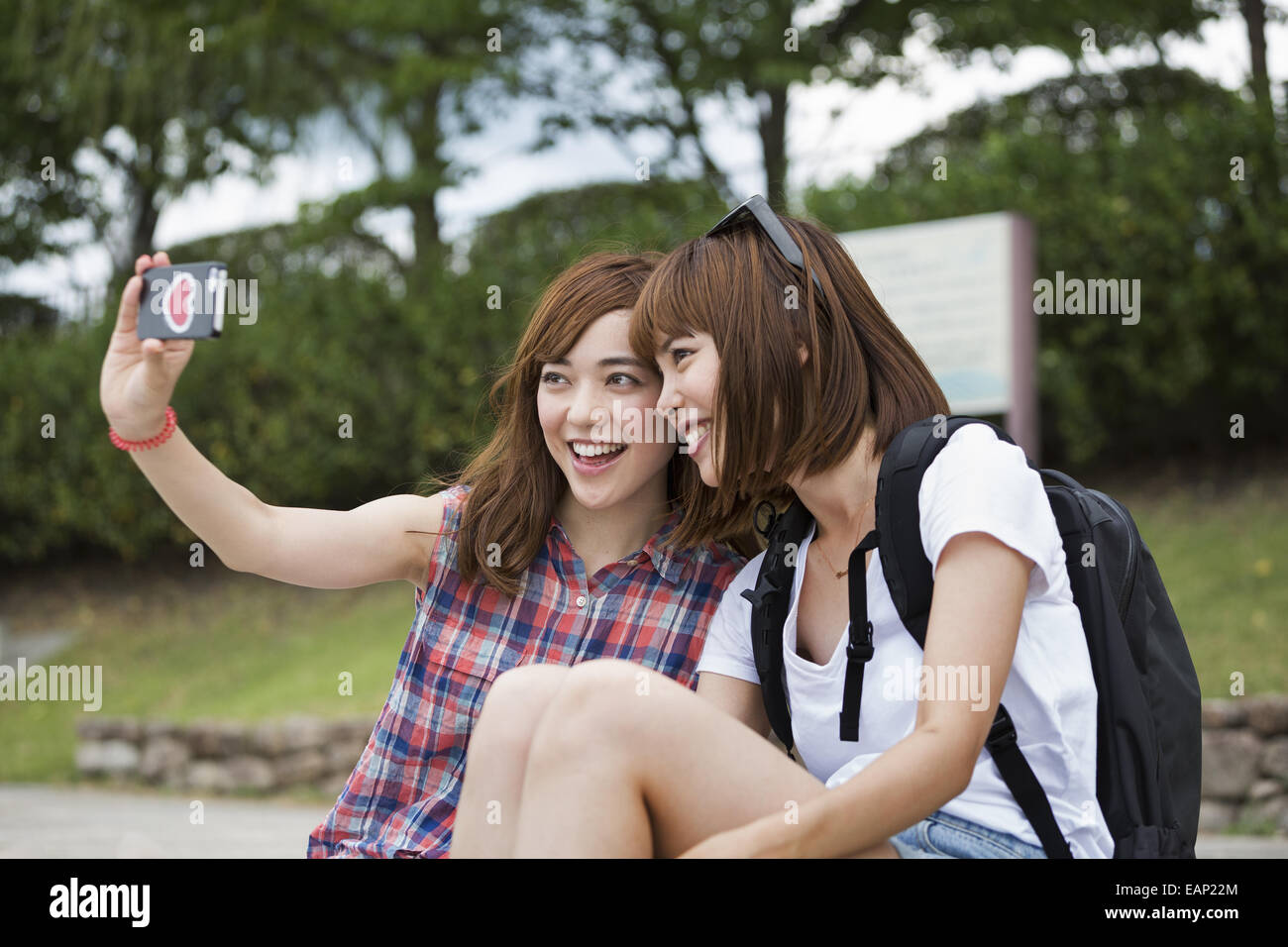 Due donne, amici prendendo un selfie nel parco. Foto Stock