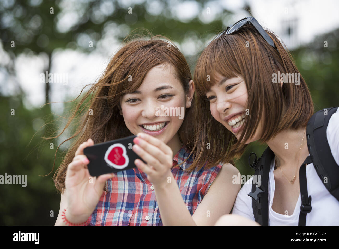 Due donne, amici prendendo un selfie nel parco. Foto Stock