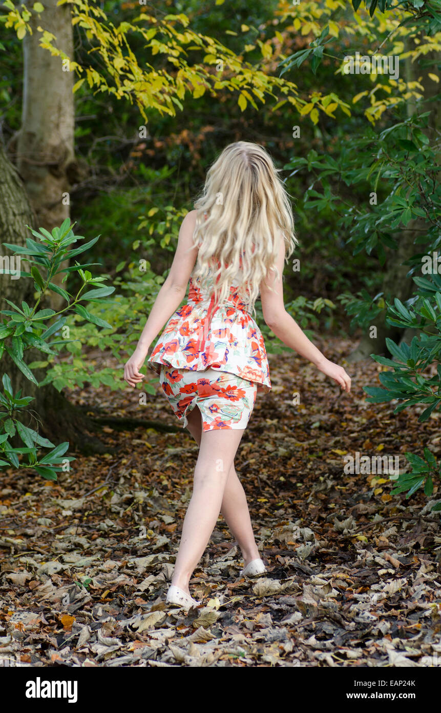 Giovane donna bionda a piedi nei boschi Foto Stock