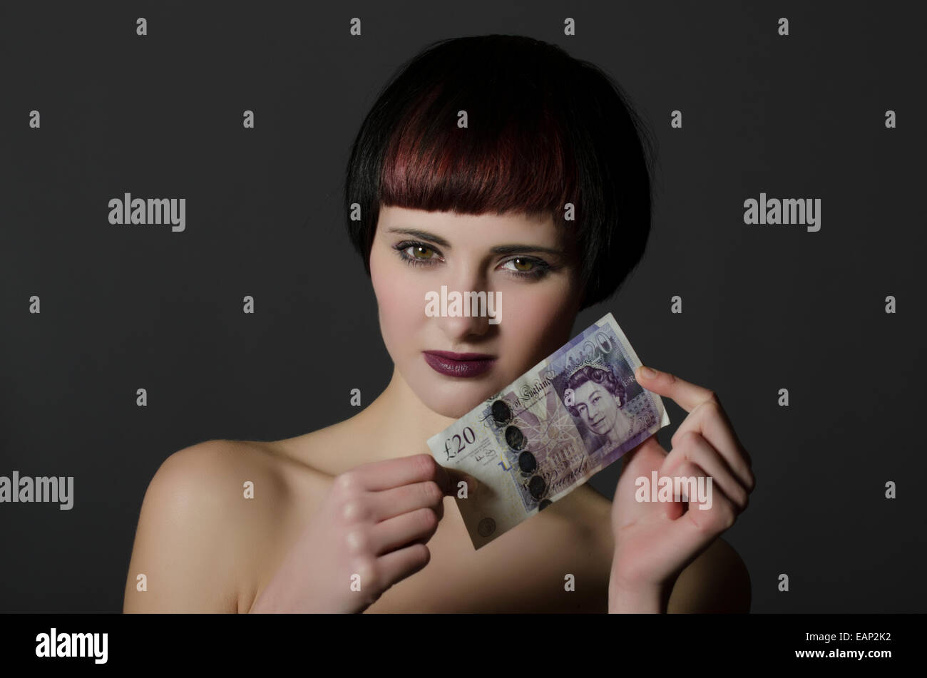 Giovane donna holding 20 sterline banconota Foto Stock