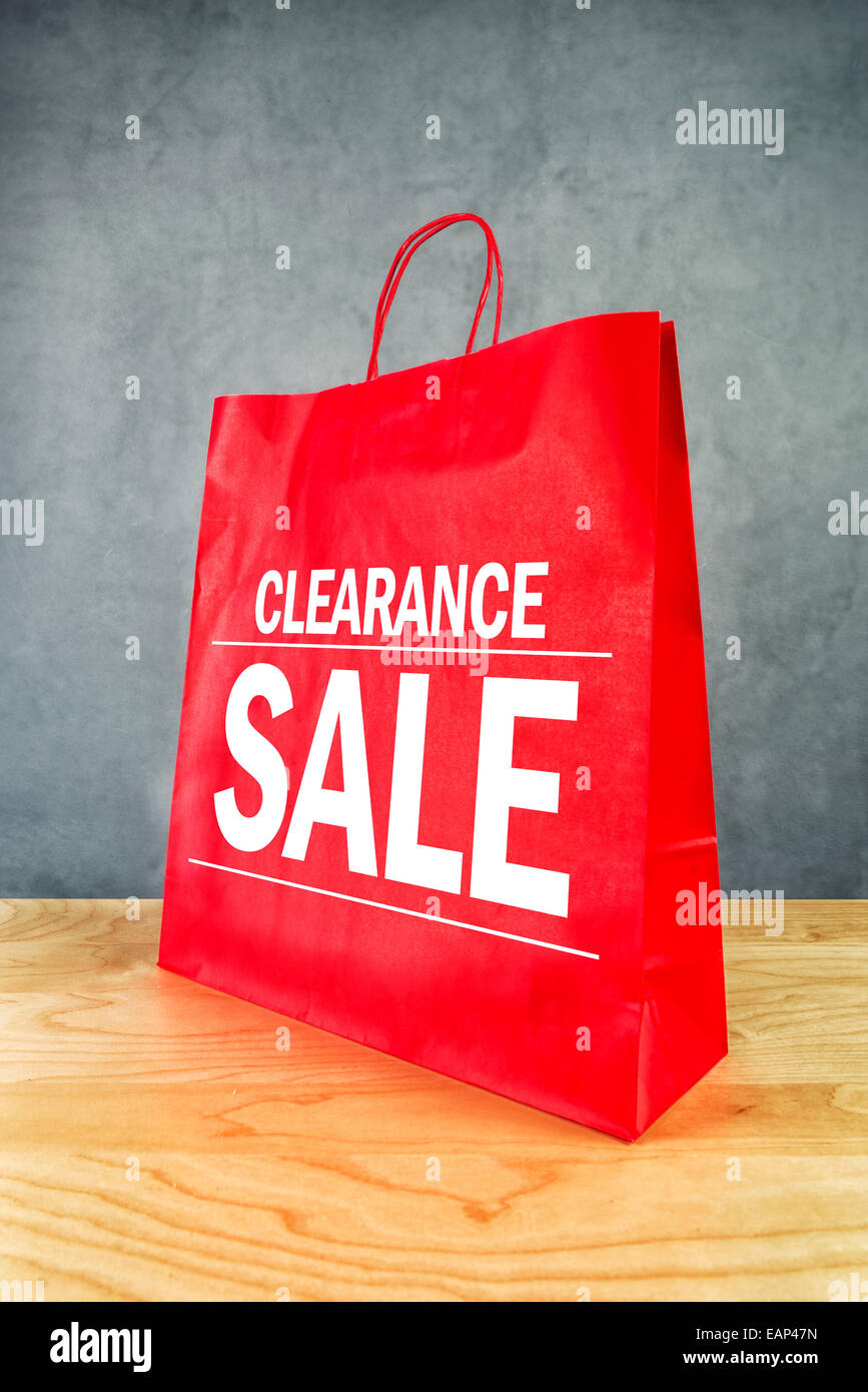 La vendita di liquidazione carta rossa Shopping Bag su legno Store TAVOLO. Foto Stock