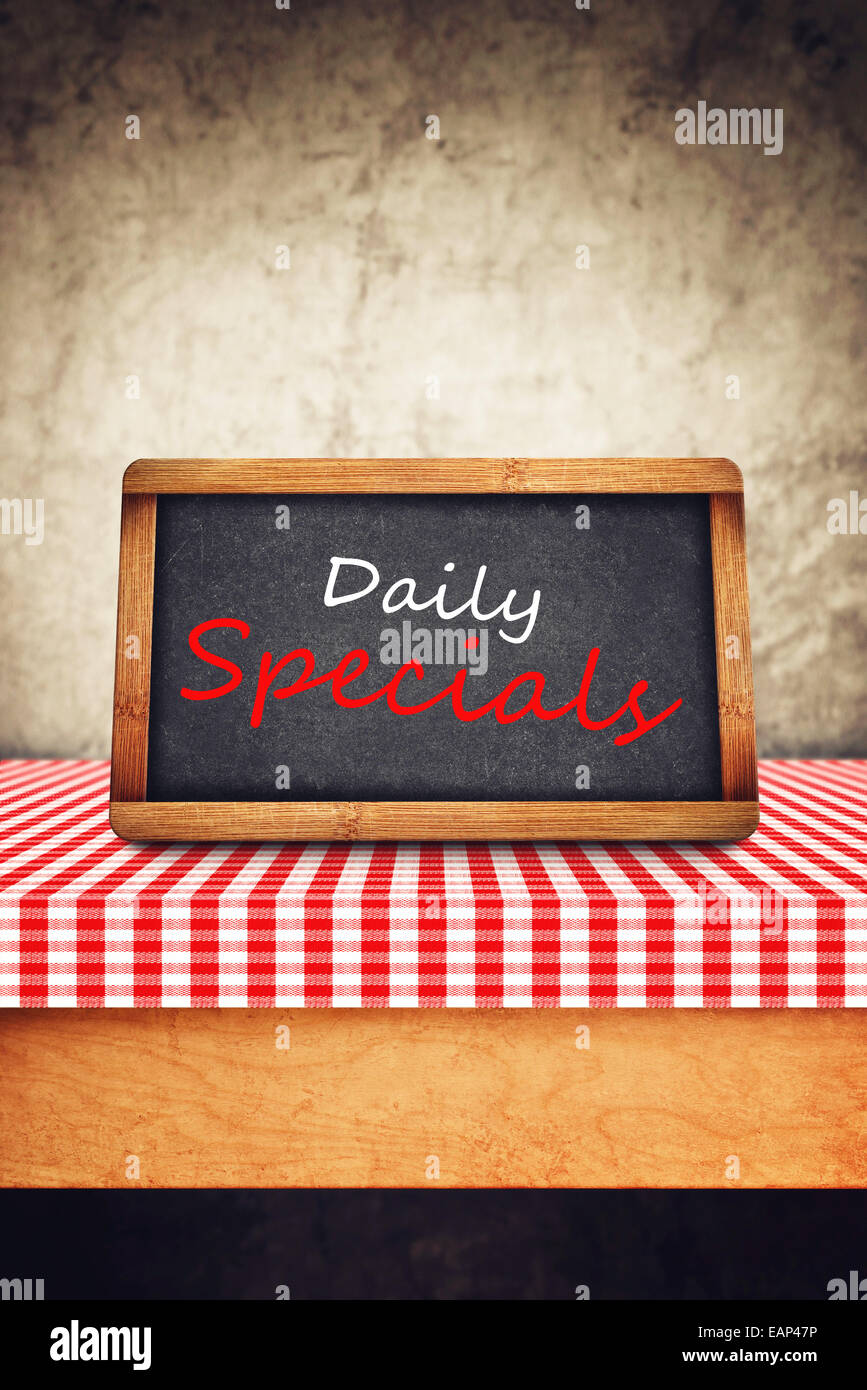Daily Specials titolo in bianco gesso sulla lavagna ristorante. Alimentazione e Nutrizione dello sfondo. Foto Stock