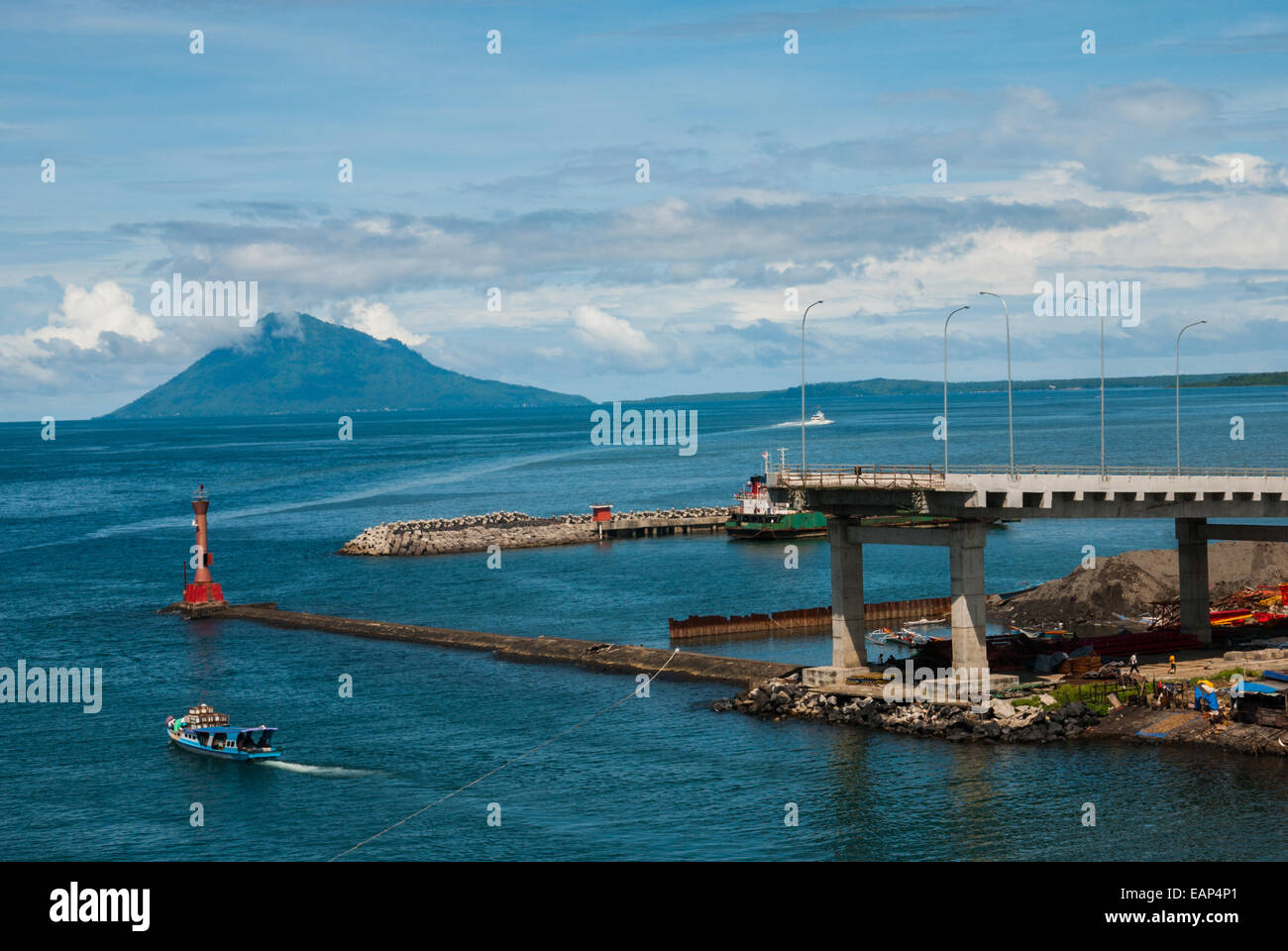 Vista della baia di Manado con il Monte Manado Tana in primo piano di un faro e parte di un ponte in costruzione a Manado, Indonesia. Foto Stock