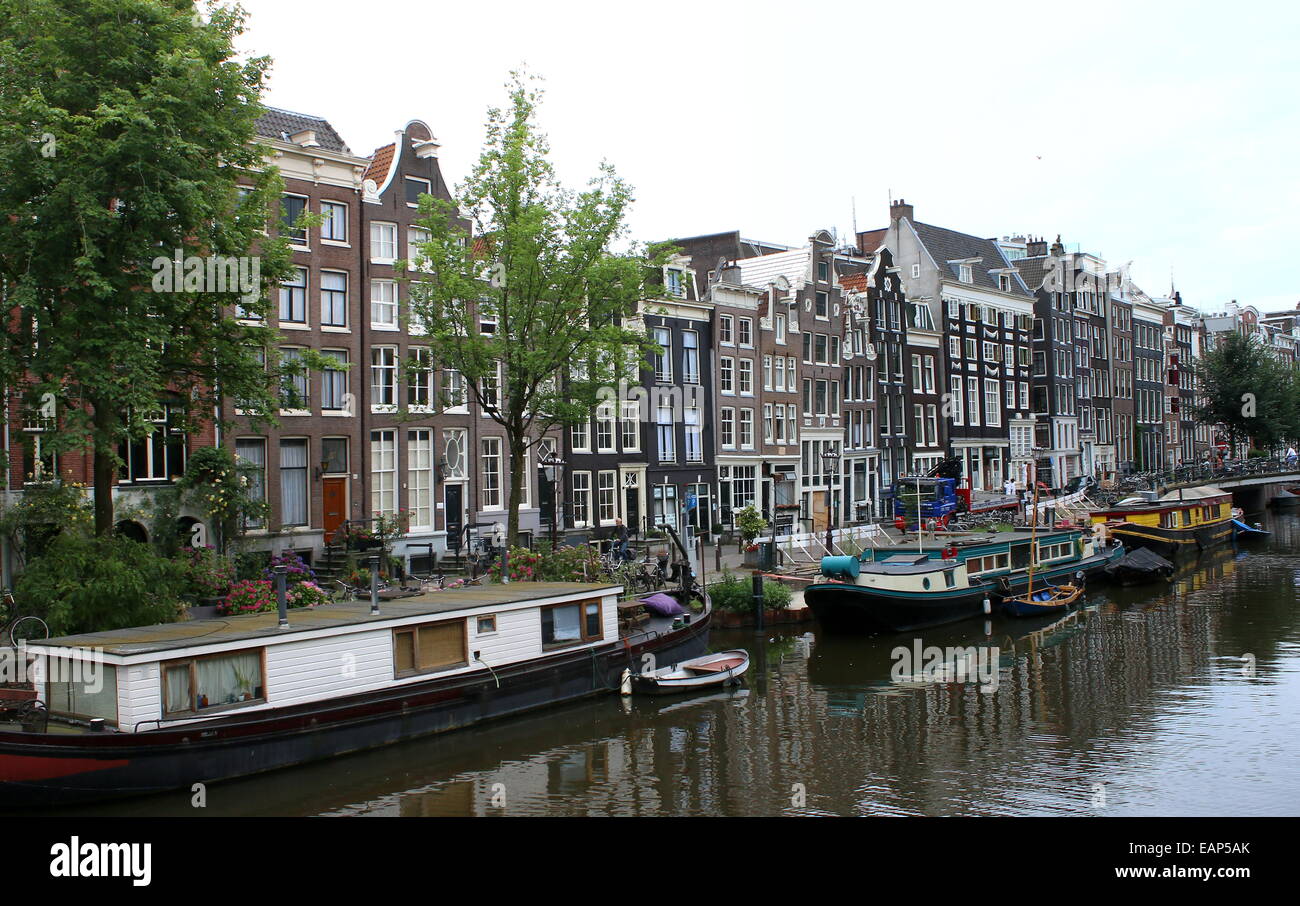 Case galleggianti lungo il canale Prinsengracht con il XVII secolo Westerkerk ad Amsterdam nei Paesi Bassi in background Foto Stock