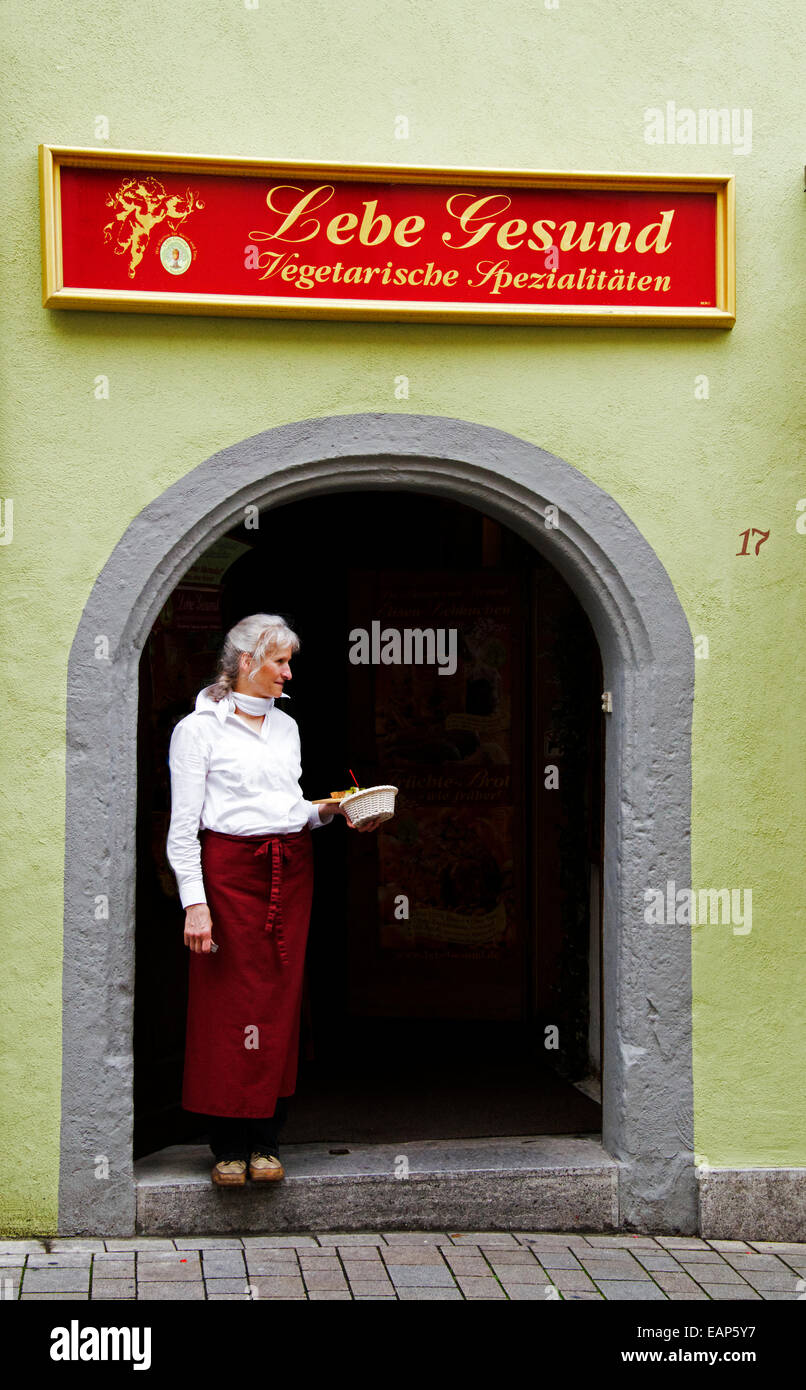 Donna in piedi in entrata al ristorante vegetariano Rothenburg ob der Tauber Germania Foto Stock