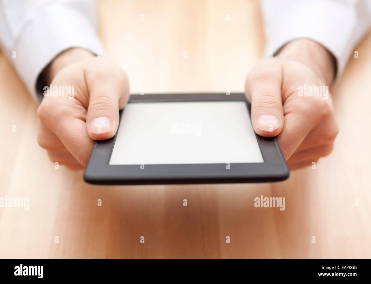 Tablet PC o lettore di e-book in mani su uno sfondo di legno Foto Stock