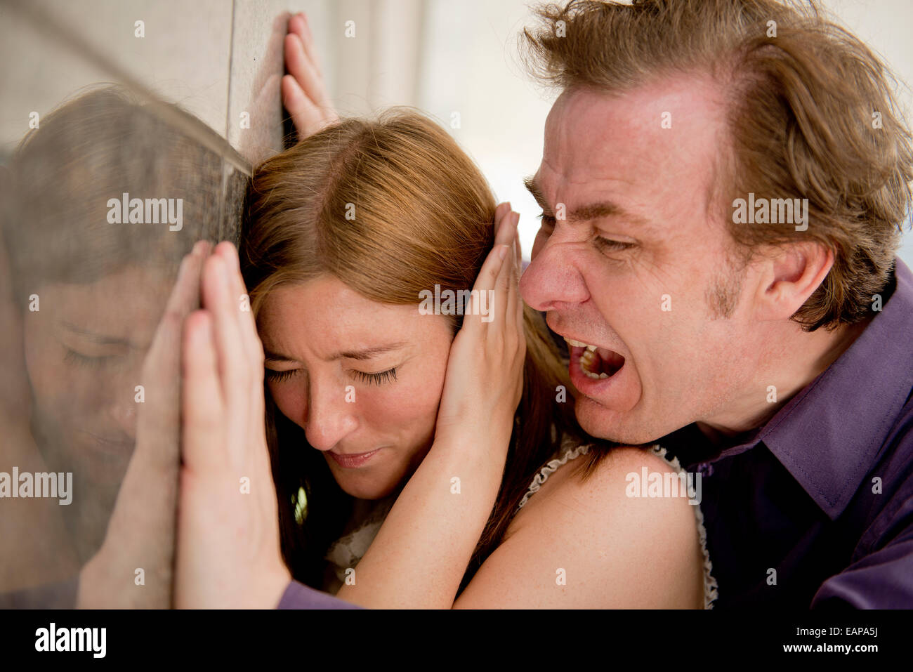 L'uomo arrabbiato grida ed essendo minaccioso contro una donna inerme. Foto Stock