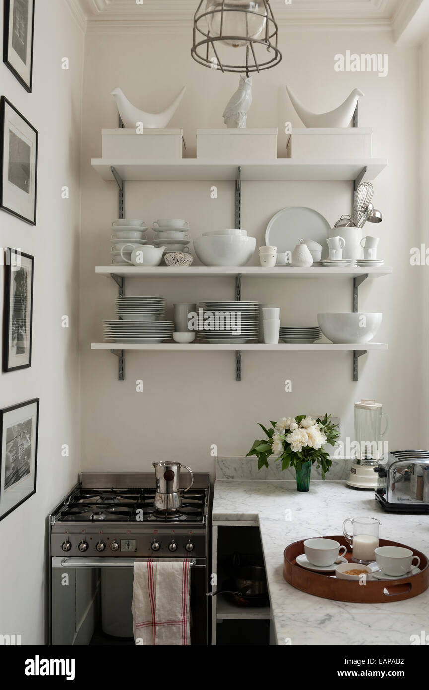 Stoviglie da tavola bianco su scaffali aperti in stile cucina cucina con superfici in marmo Foto Stock