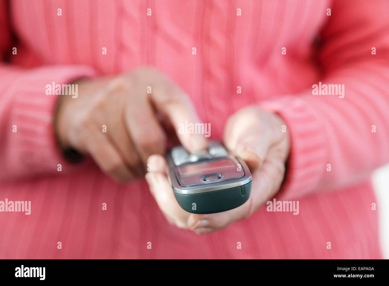 Una donna anziana con la mano destra che utilizza la tastiera del telefono per comporre un numero di telefono per effettuare una chiamata da casa. Inghilterra, Regno Unito, Gran Bretagna Foto Stock