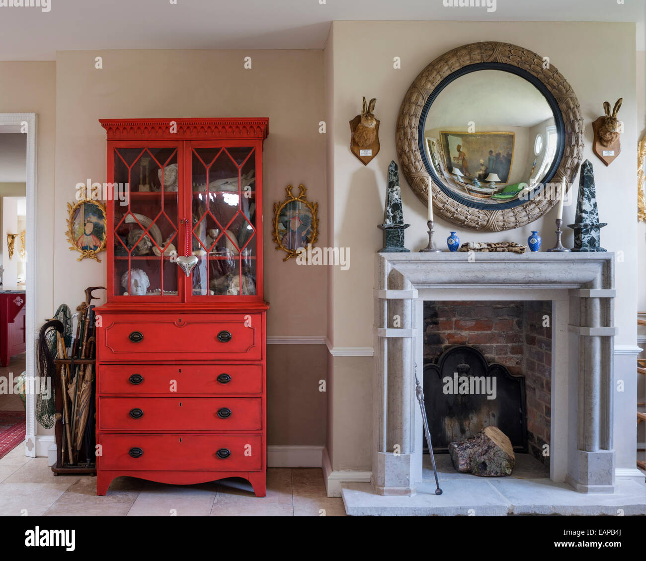 George III periodo secretaire in mogano verniciato in un rosso mescolato da Farrow & Ball dal camino di pietra Foto Stock
