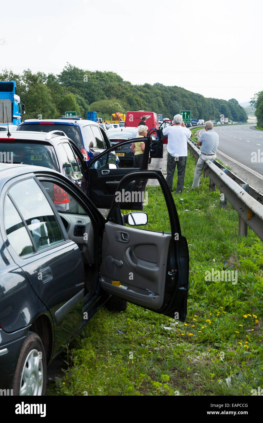 Il traffico a fermo / non si muove a causa di incidente. In attesa driver / passeggeri hanno lasciato auto e veicoli a chiedersi su strada Foto Stock