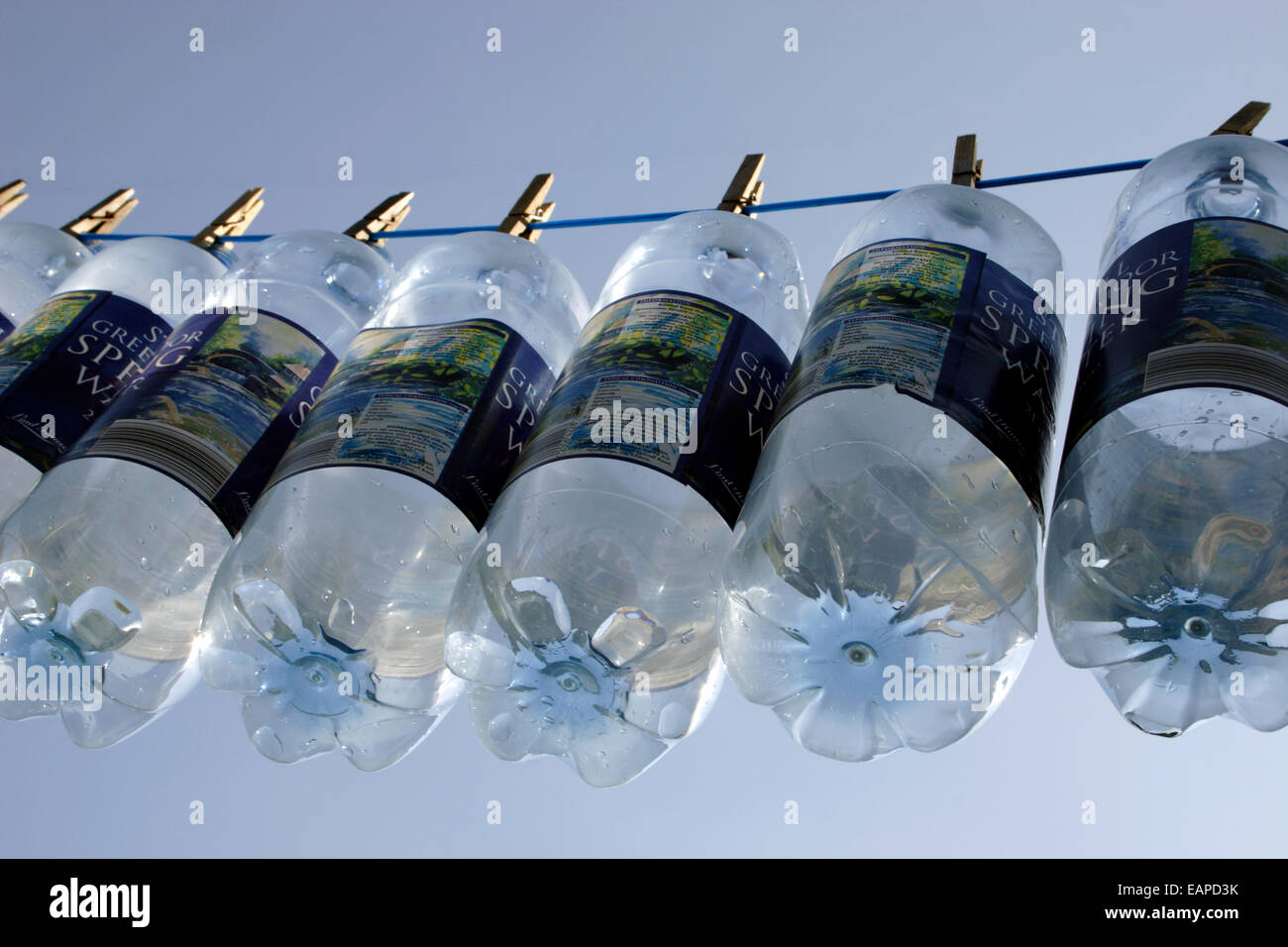 Molla in plastica bottiglie di acqua appesa sulla linea Foto Stock