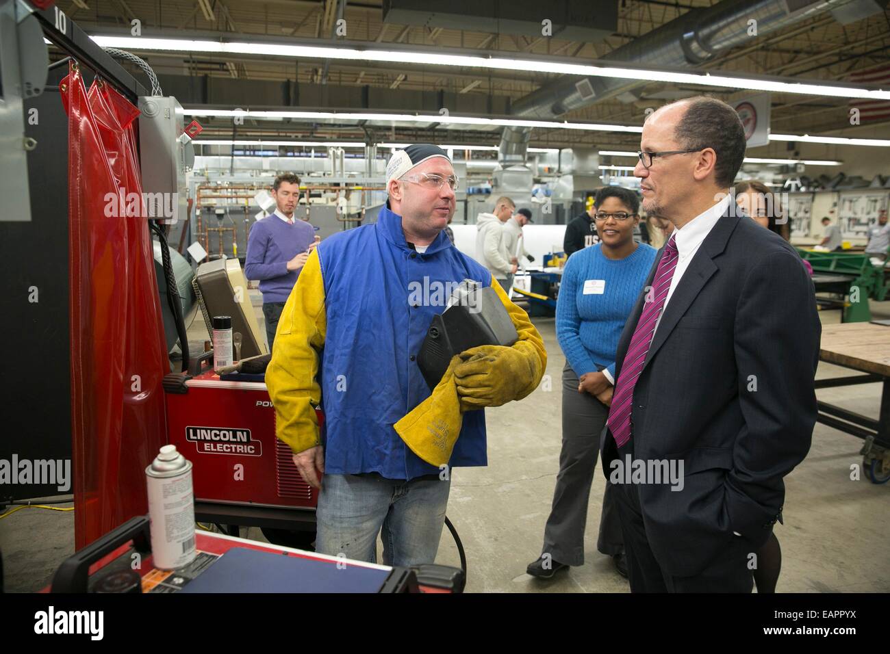 Noi segretario di lavoro Thomas Perez soddisfa con Greg Leonard un terzo anno apprendista saldatore come egli si prende una pausa dal mig-classe di saldatura al foglio di lamiera lavoratore dell'Unione Hall Novembre 17, 2014 a Boston, MA. Foto Stock