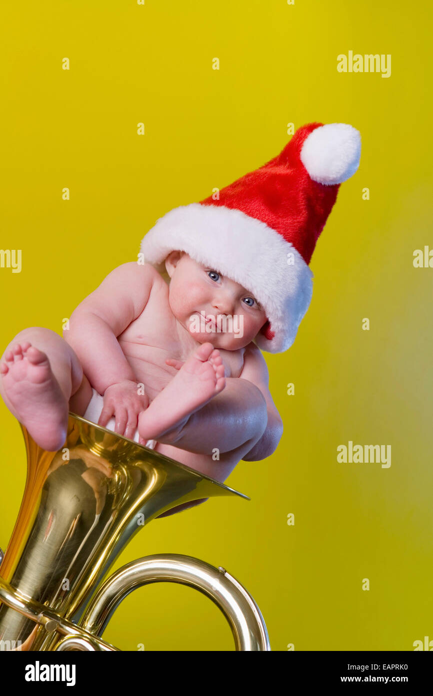 Caucasian Infant Girl indossando Santa Claus Hat seduta nella campana di un baritono strumento Alaska Foto Stock