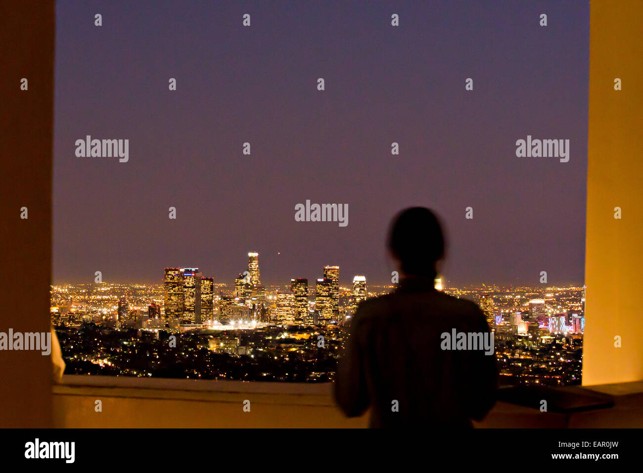 Una donna opinioni il Los Angeles City paesaggio presso l'Osservatorio Griffith appena dopo il tramonto. Foto Stock
