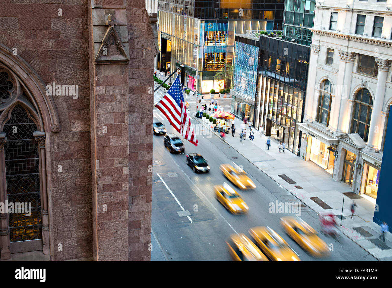 La bandiera americana onde come taxi guidare su strada nella città di New York, NY. Foto Stock