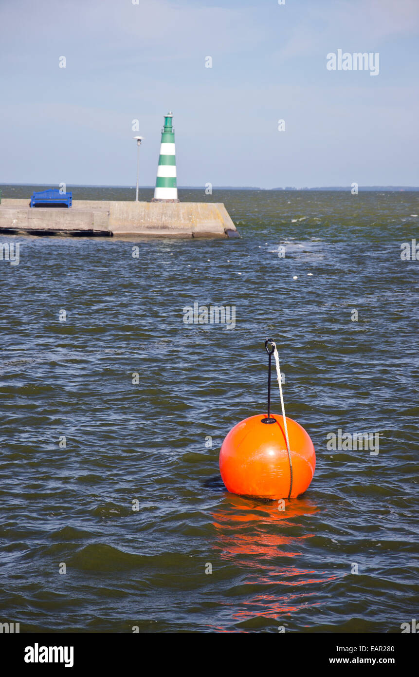 Boa arancione e il faro nella località di mare dock Foto Stock