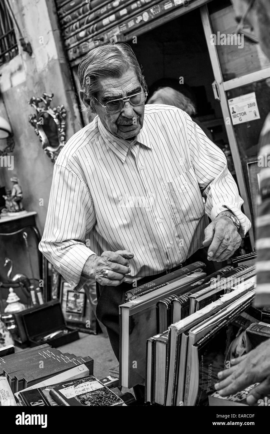 Uomo vecchio controllo di libri al mercato in Madrid Foto Stock