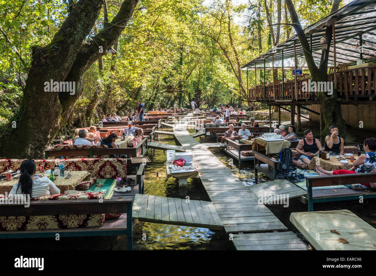 Pesce BOTANIK festaurant nella foresta costiera, posti a sedere sopra le acque delle trote, Ulupınar, Provincia di Antalya, Turchia Foto Stock
