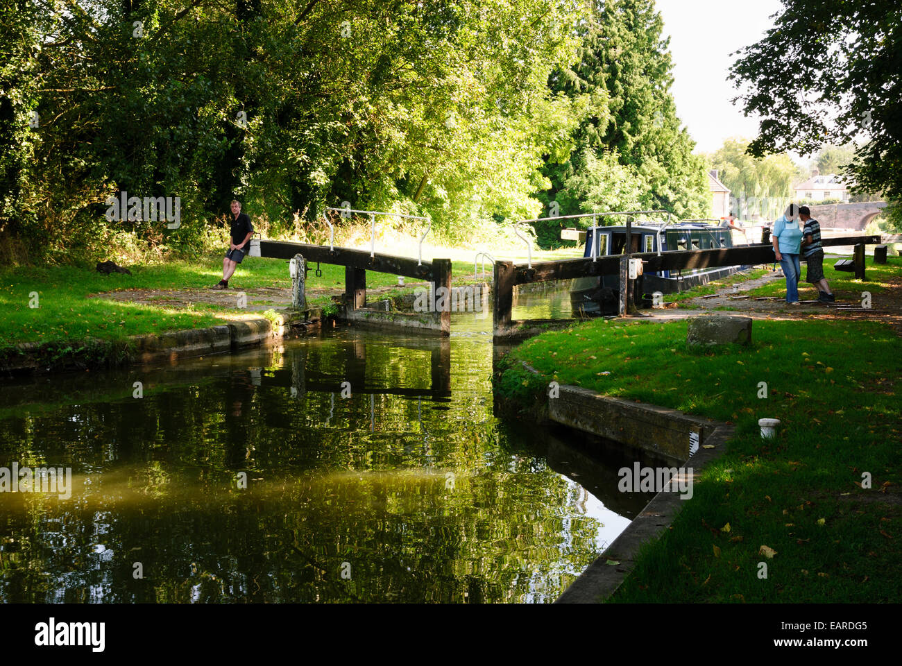 L uomo e la donna l'apertura bloccare il portellone per barca stretta a Hungerford sul Kennet and Avon Canal Foto Stock