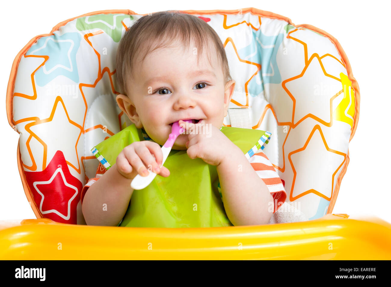 Happy baby bambino seduto in poltrona con un cucchiaio Foto Stock