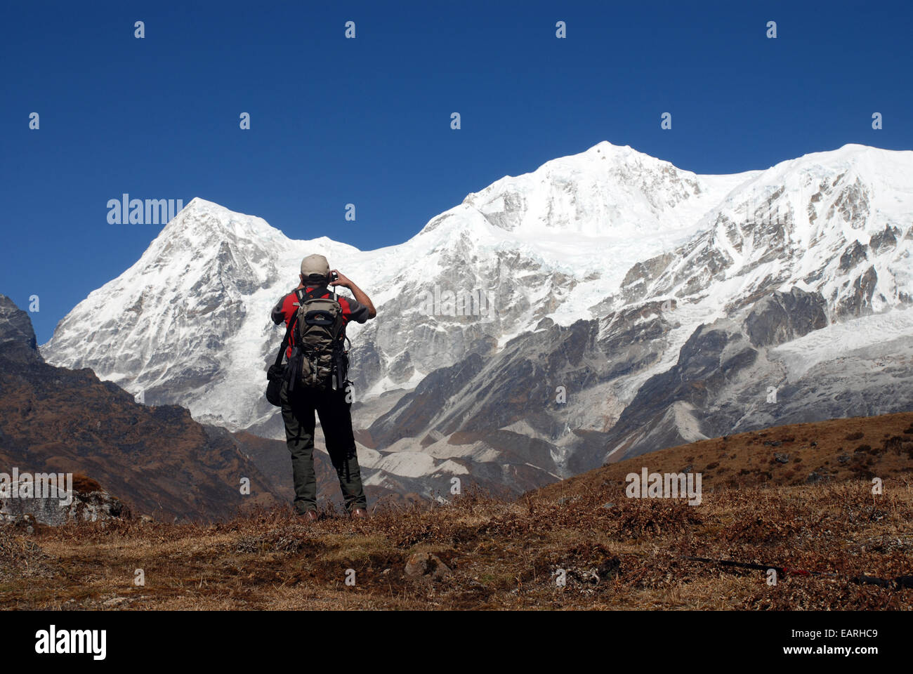 Un trekker fotografie le alte vette dell'Himalaya indiano nello stato del Sikkim Foto Stock