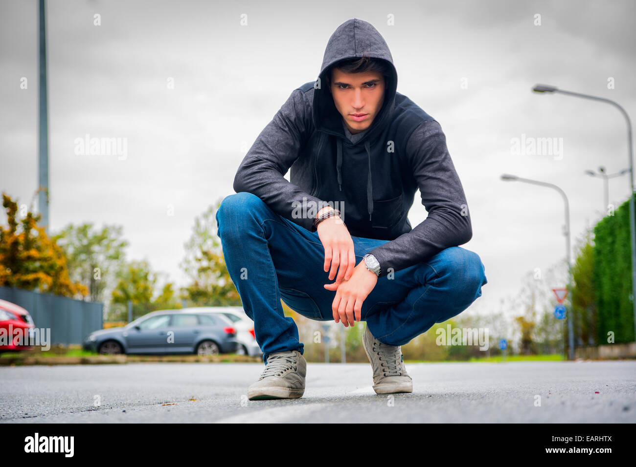 Attraente giovane con felpa con cappuccio e cappello da baseball in strada  di città, guardando la fotocamera Foto stock - Alamy