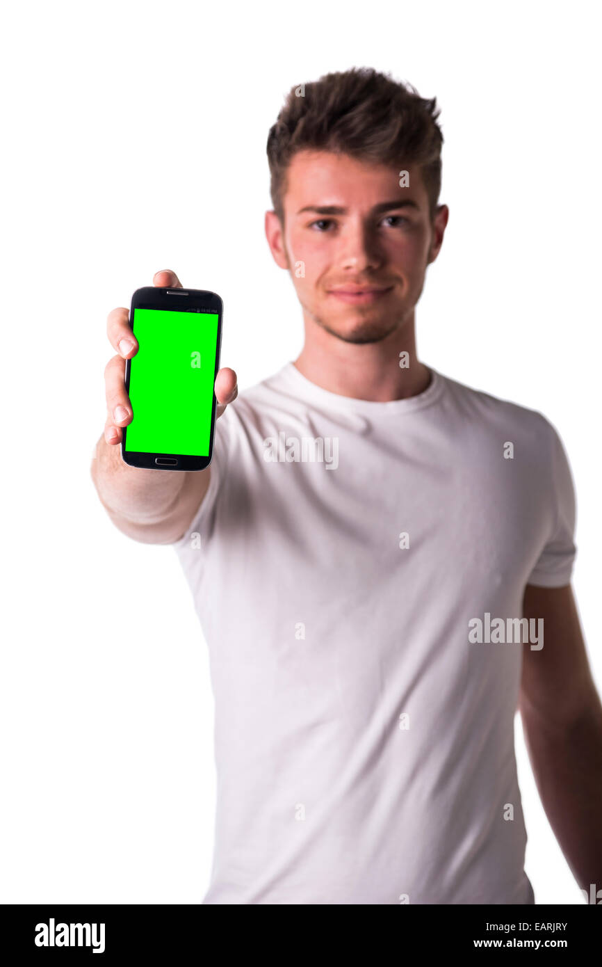 Attraente giovane uomo o ragazzo che mostra il suo telefono cellulare è vuota dello schermo verde, isolato su bianco Foto Stock