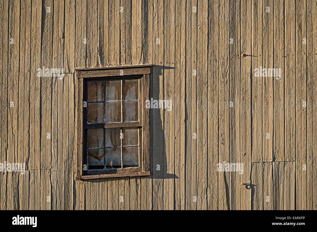 Vecchia finestra inclinata su sgangherato stalla diroccata Foto Stock