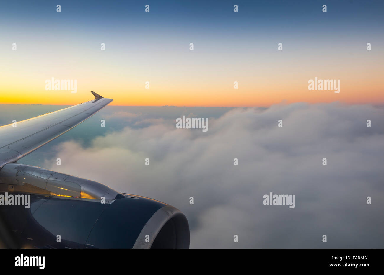 Ala di aeroplano e nuvole con il tramonto del sole Foto Stock