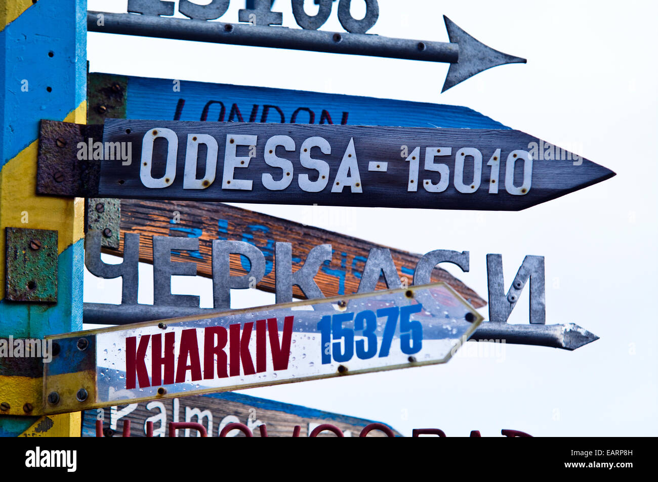 Un segno direzionale in corrispondenza di una stazione di ucraini punti alla città distanti. Foto Stock
