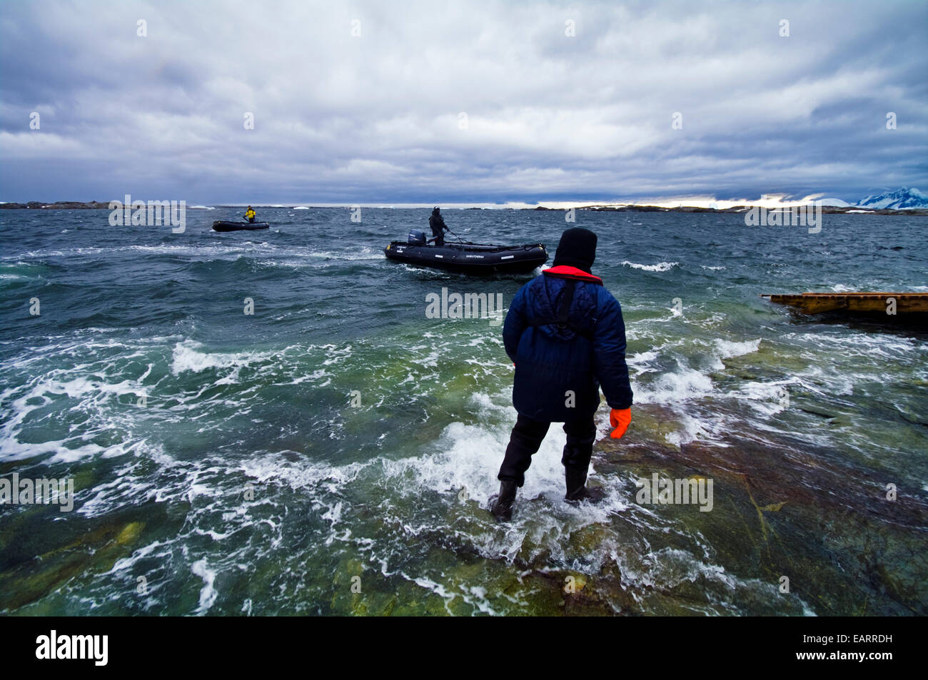 'Equipaggio della nave in isolati tute impermeabili attorno al carico barche zodiac. Foto Stock
