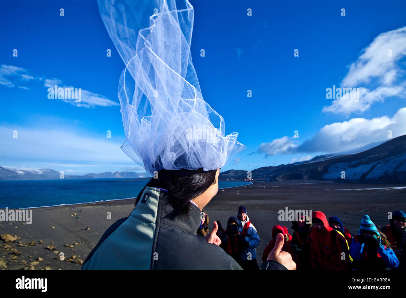 Un sposi sposa dà il pollice in su dopo il suo matrimonio in Antartide. Foto Stock