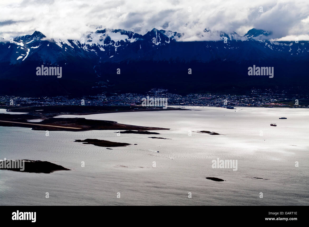 Nuvole temporalesche scendere sopra le montagne delle Ande al di sopra di una vasta città. Foto Stock