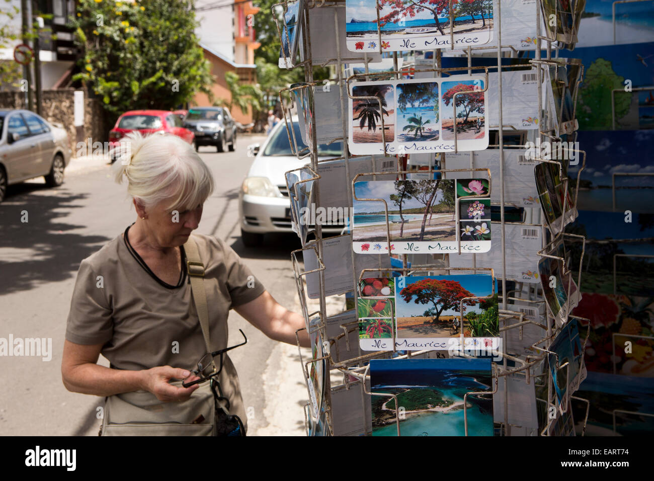 Mauritius Grand Baie, femmina senior tourist shopping per le cartoline nel negozio di souvenir Foto Stock