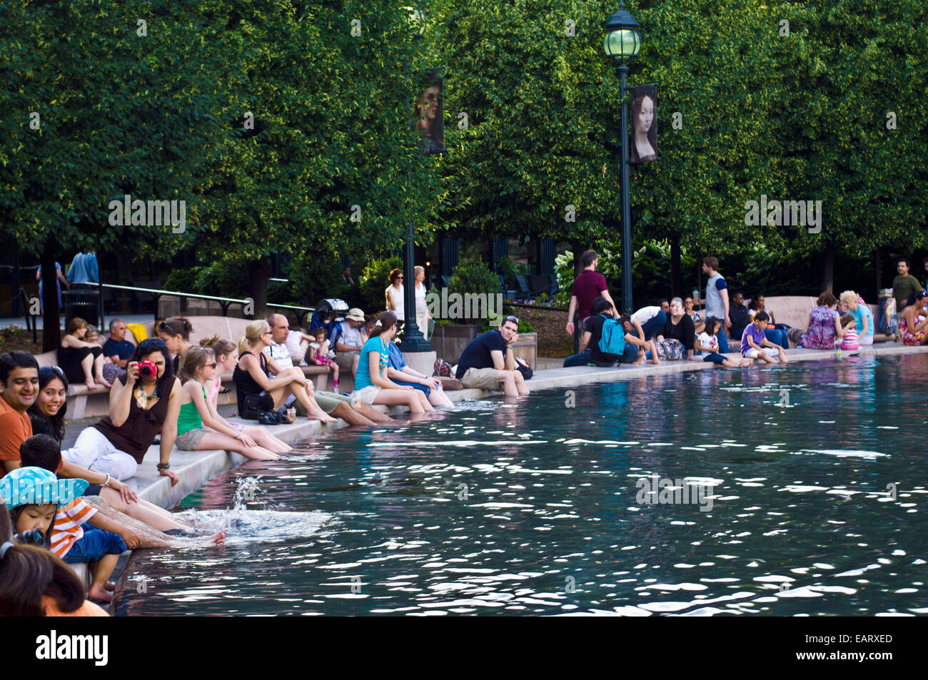 I turisti raffreddare i loro piedi in una piscina con fontana del Memorial Day. Foto Stock