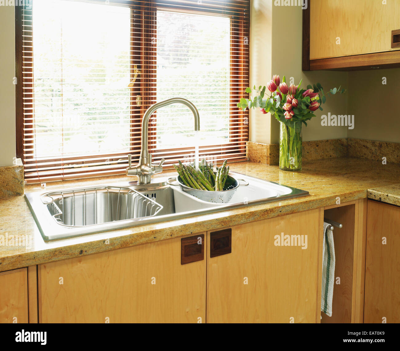 Acqua che scorre da toccare il montaggio su asparagi con scolapasta nel lavello  da cucina Foto stock - Alamy