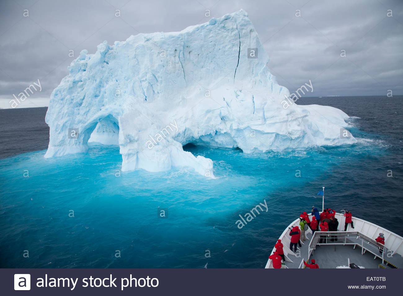 I turisti scattare delle foto di un iceberg dalla prua di una nave da crociera. Foto Stock