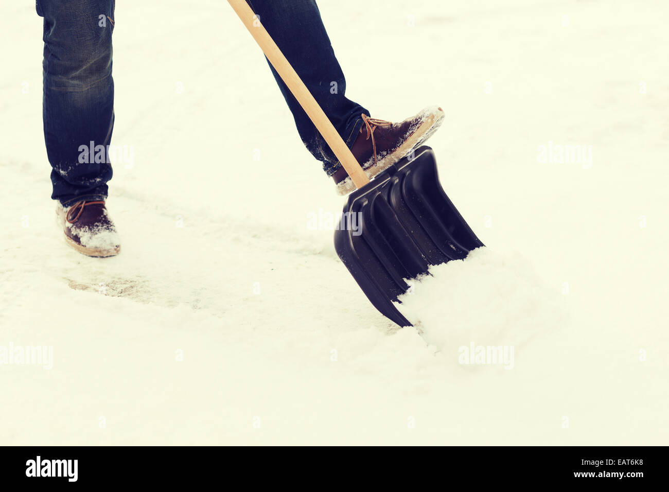 Primo piano dell'uomo spalare la neve dal viale di accesso Foto Stock