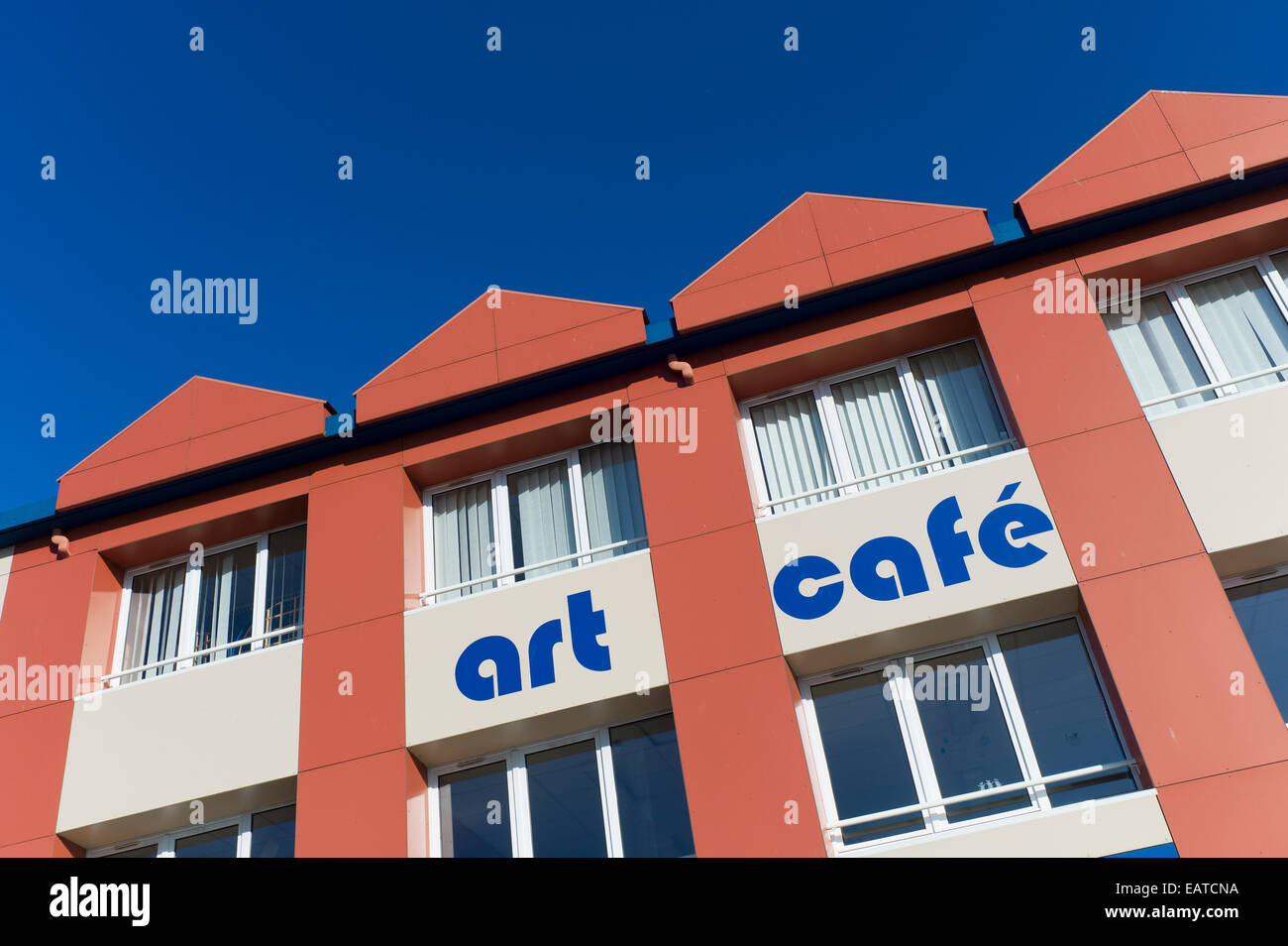 Moderno edificio di colore arancione art cafe contro il cielo blu Foto Stock