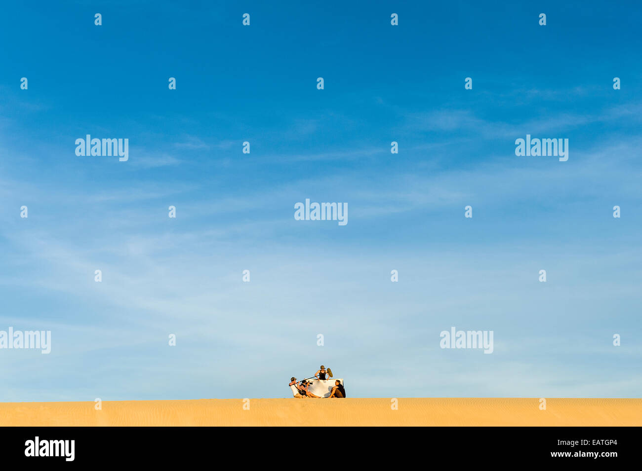 Una troupe cinematografica registra un intervista su un litorale di dune di sabbia al tramonto. Foto Stock