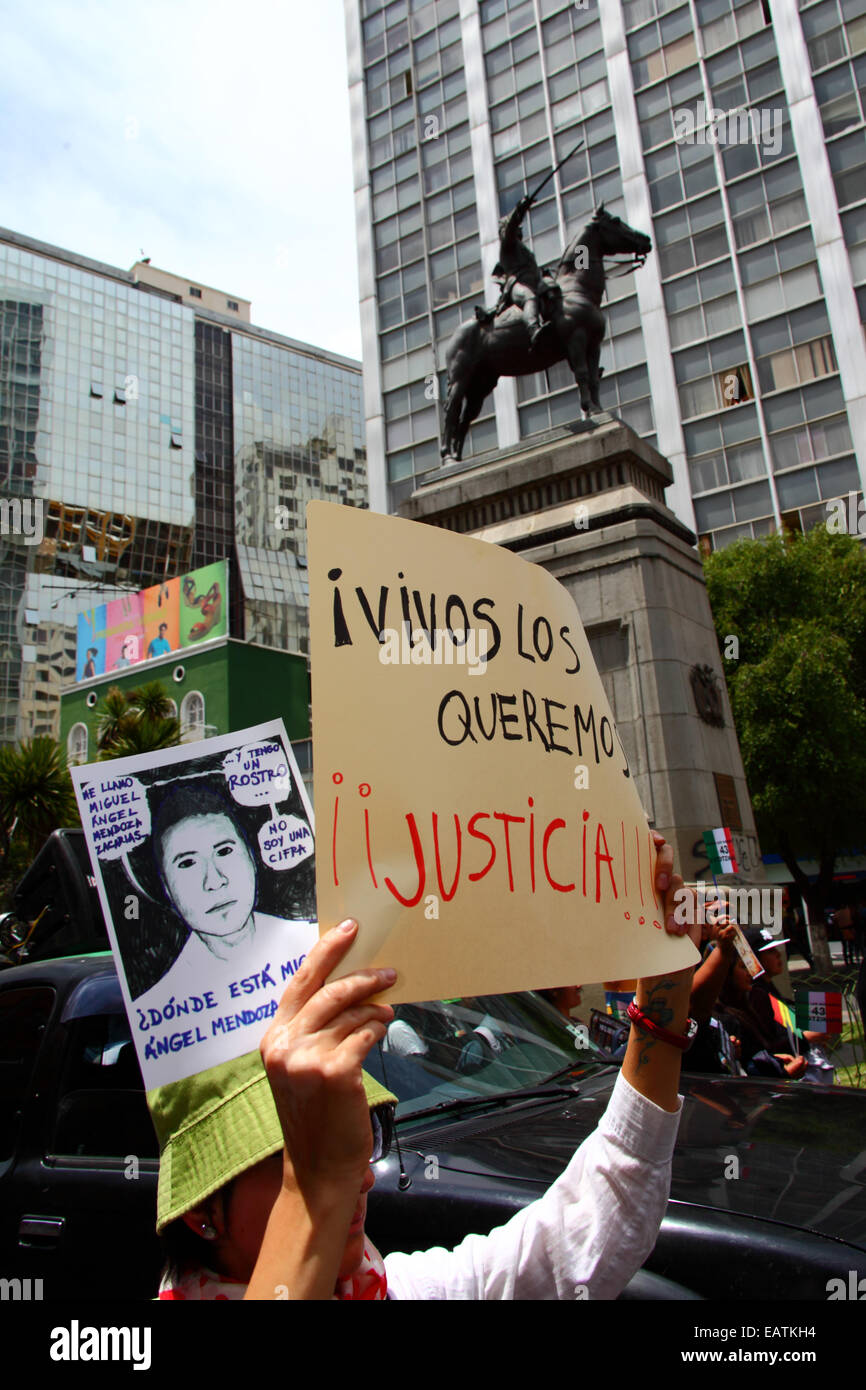 La Paz in Bolivia. Xx Novembre, 2014. Manifestanti passa una statua di Simón Bolivar durante una marcia per chiedere giustizia per i 43 studenti mancanti in Messico e di protesta contro il governo messicano per la gestione del caso e la corruzione. La giornata di oggi è stata designata una giornata di azione globale per Ayotzinapa; uno sciopero nazionale è prevista in Messico e molti si stanno svolgendo le proteste in tutto il mondo per mostrare il loro sostegno. Gli studenti sono scomparsi dopo scontri con la polizia la notte del 26 settembre nella città di Iguala. Credito: James Brunker/Alamy Live News Foto Stock