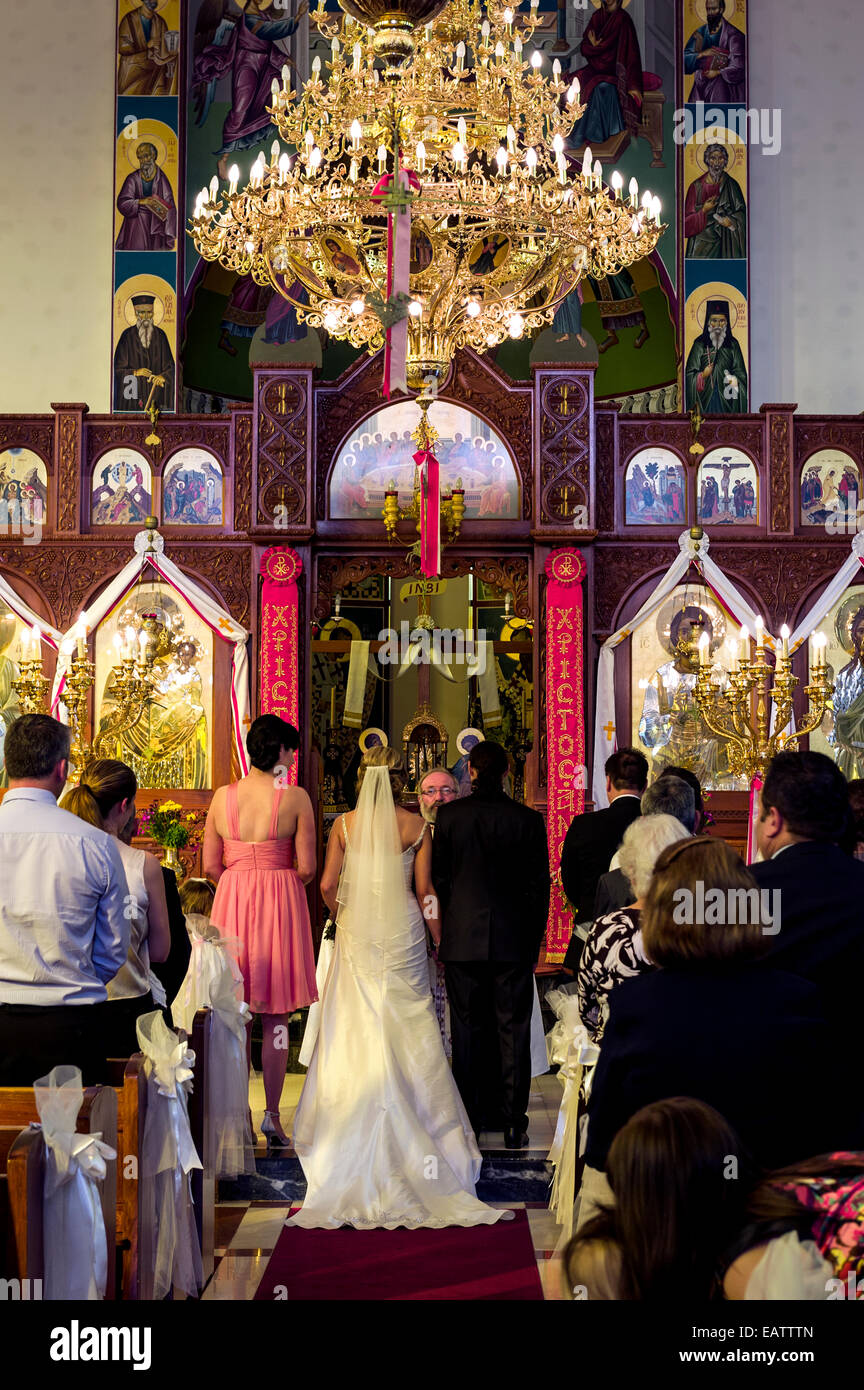 Gli ospiti unirsi in preghiera e celebrazioni in un greco ortodosso di matrimonio. Foto Stock