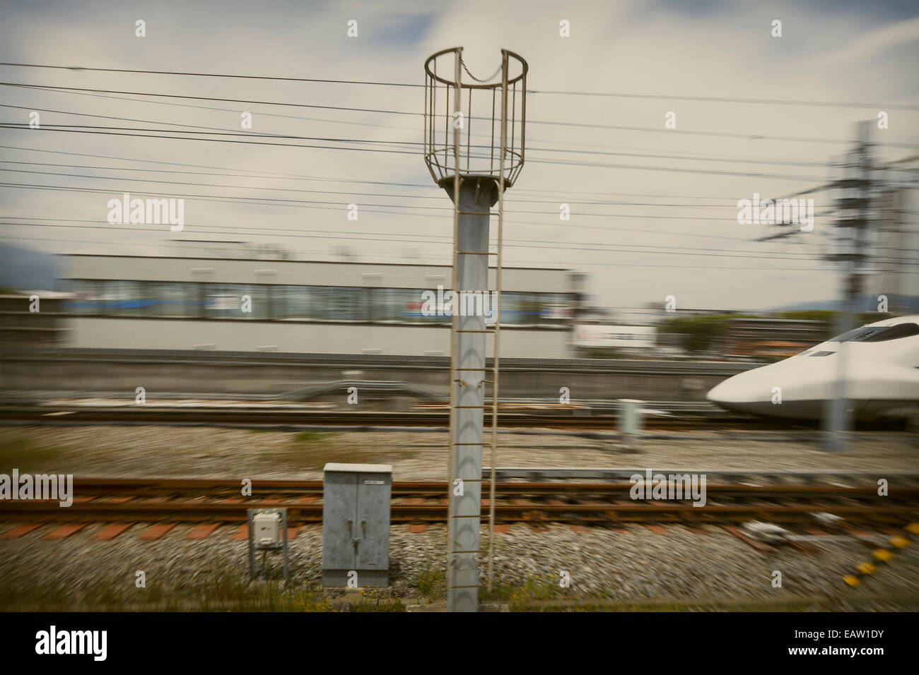 Giappone bullet train corre sulla sua via contro lo sfondo di sfocato paesaggio urbano. Foto Stock